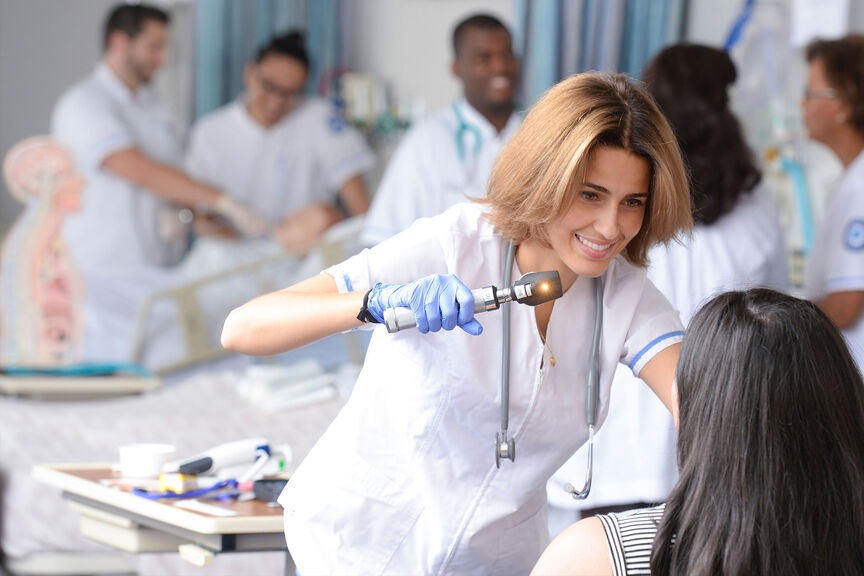 A female nursing student practices patient examinations in our skills lab