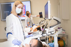 A female sonography student scanning another student