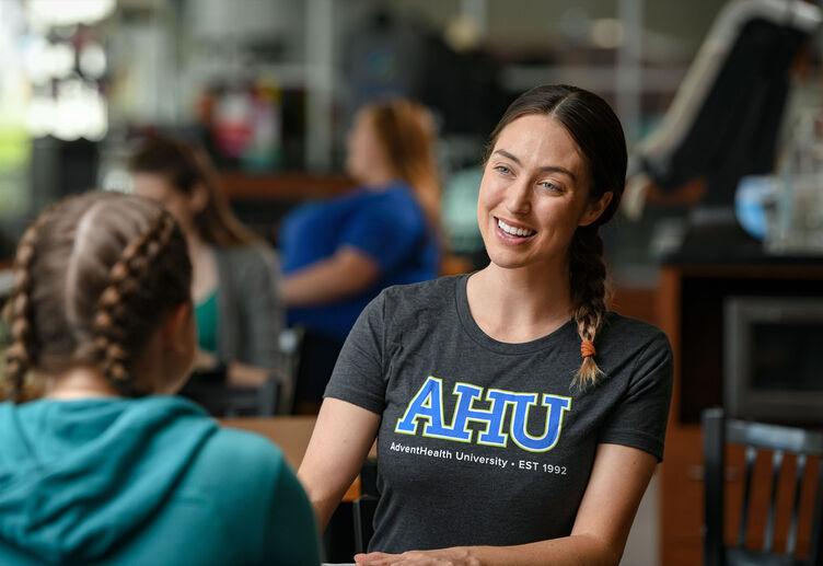 A current student conversing with a new student during orientation