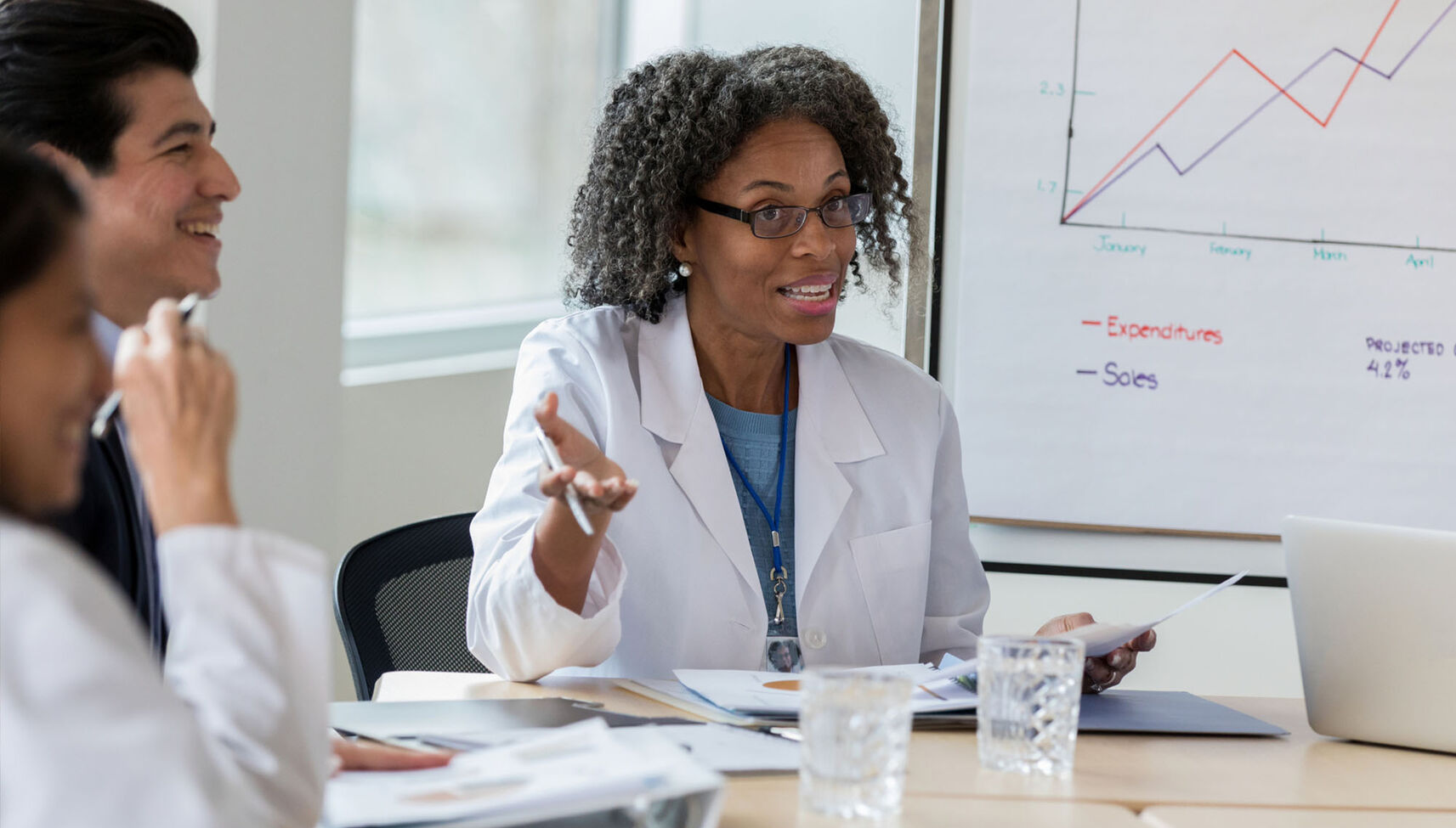 A female healthcare executive confers with her colleagues in a meeting