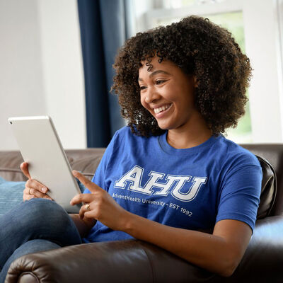 A female AHU students uses and ipad at her home