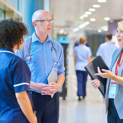 A hospital administrator converses with a doctor and nurse