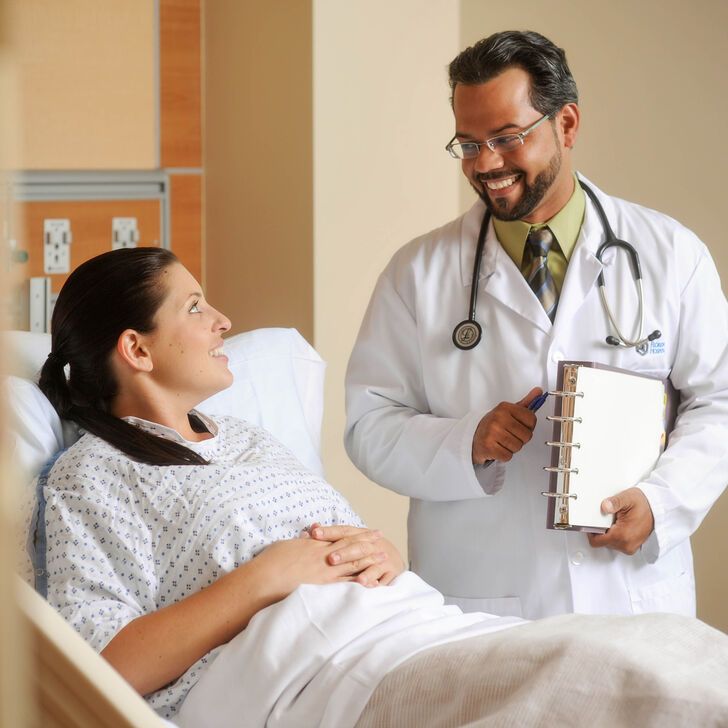 Doctor talking with patient in hospital bed