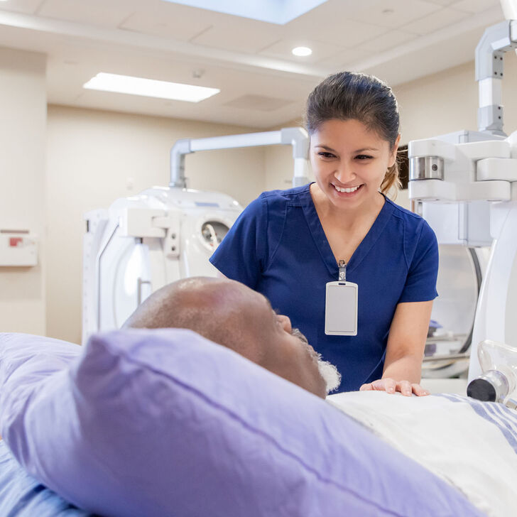 An imaging tech assuring a patient before a scan