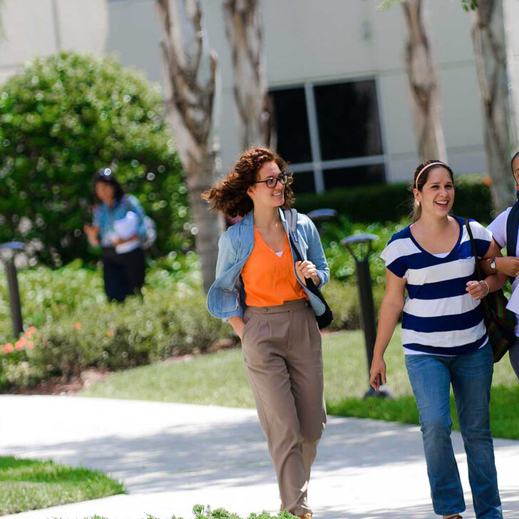 A group of students walks outside on campus